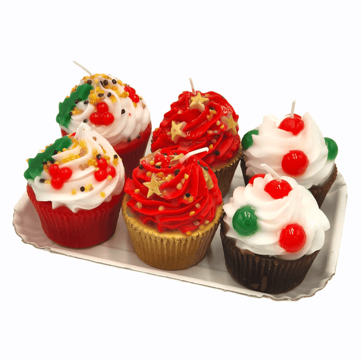 Weihnachtliche Kerzen in Cupcake-Form mit roten, weißen und goldenen Deko-Elementen auf Tablett
