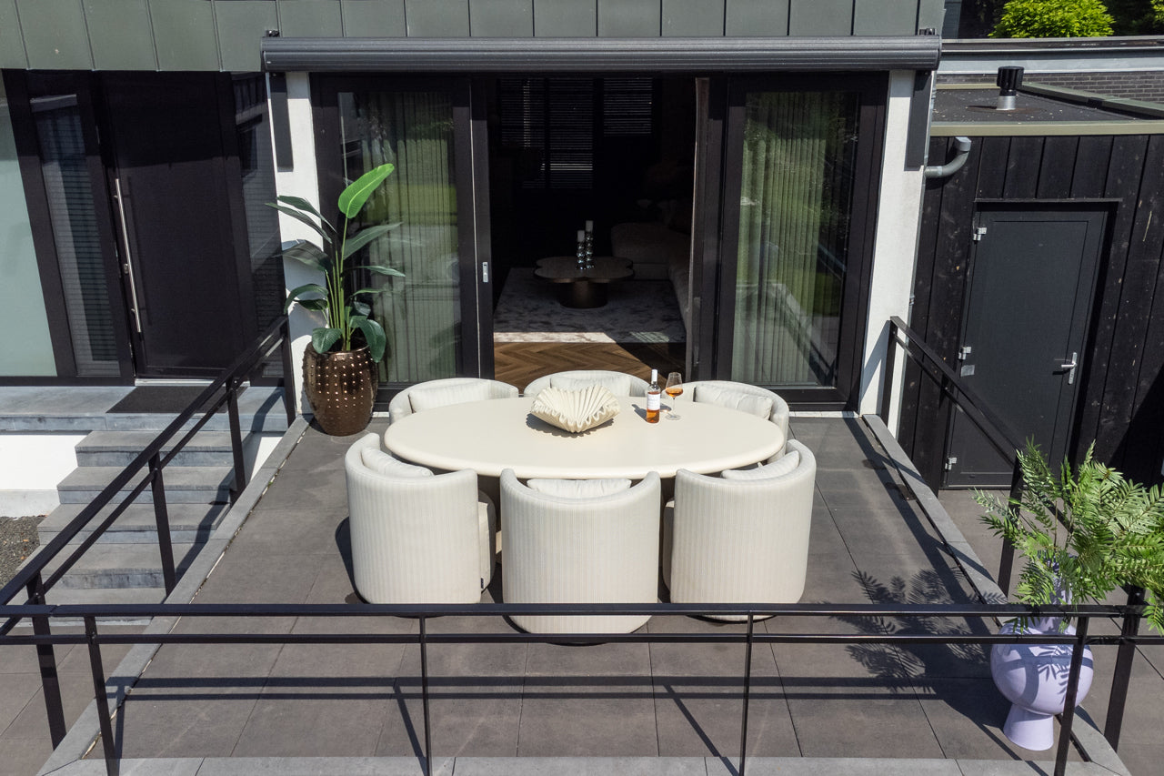 Moderne Outdoor-Lounge mit ovalem Esstisch, gepolsterten Stühlen und Pflanzen auf Terrasse, Codeso Living Style