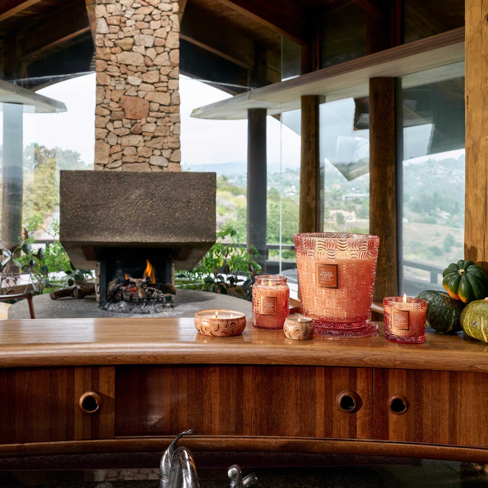 Luxus Duftkerzen auf Holztheke vor modernem Kamin, glamouröse Interior-Deko von Codeso Living