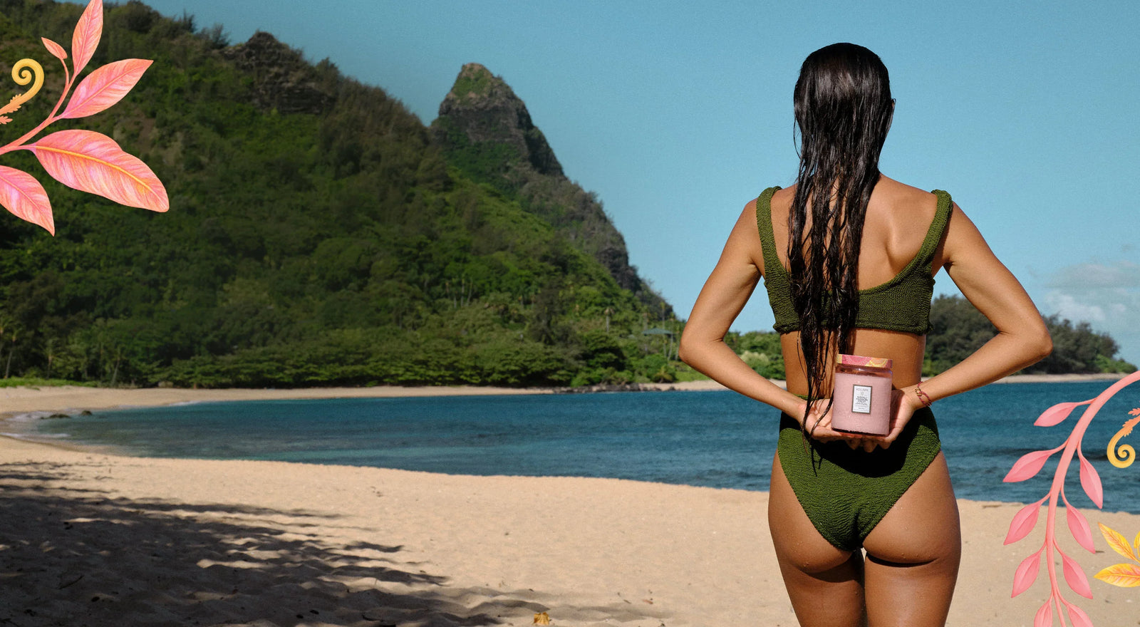 Frau im grünen Bikini am tropischen Strand mit Kerze, exotische Natur und Deko-Elemente