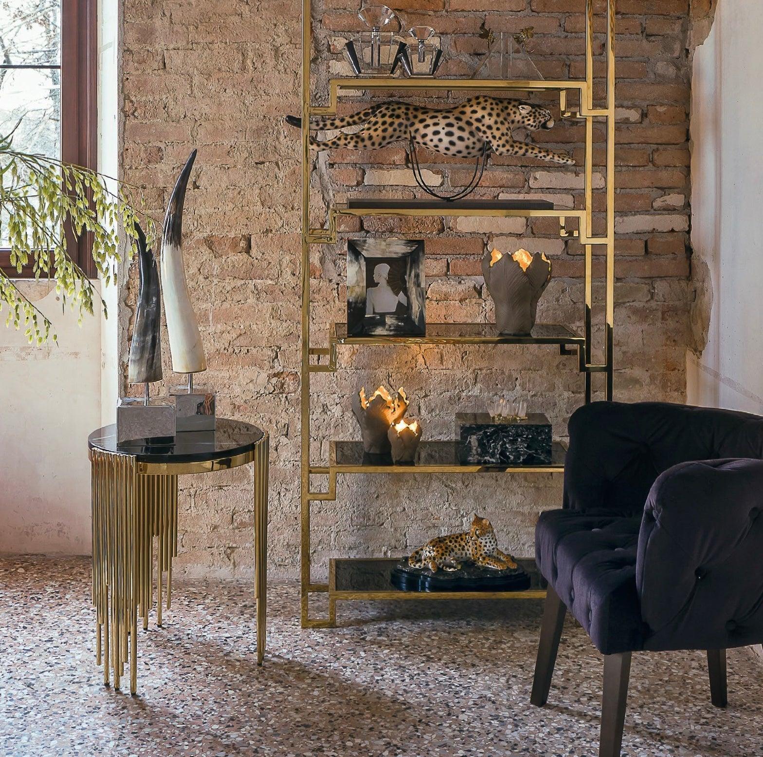 Luxuriöses Wohnzimmer-Interieur mit goldfarbenem Regal, Dekoleopard, Kunstobjekten und elegantem Sessel.