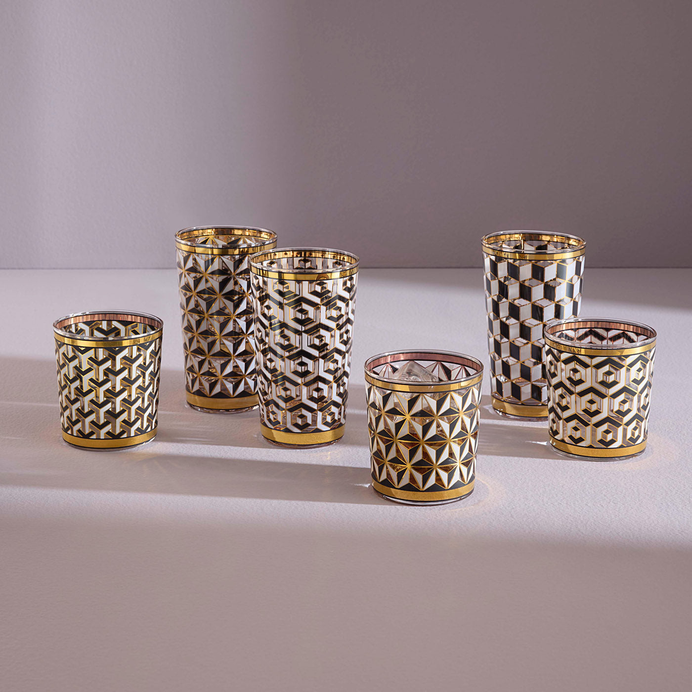Sechs Gläser mit gold-schwarzem, geometrischem Luxus-Design auf hellem Untergrund, Codeso Living