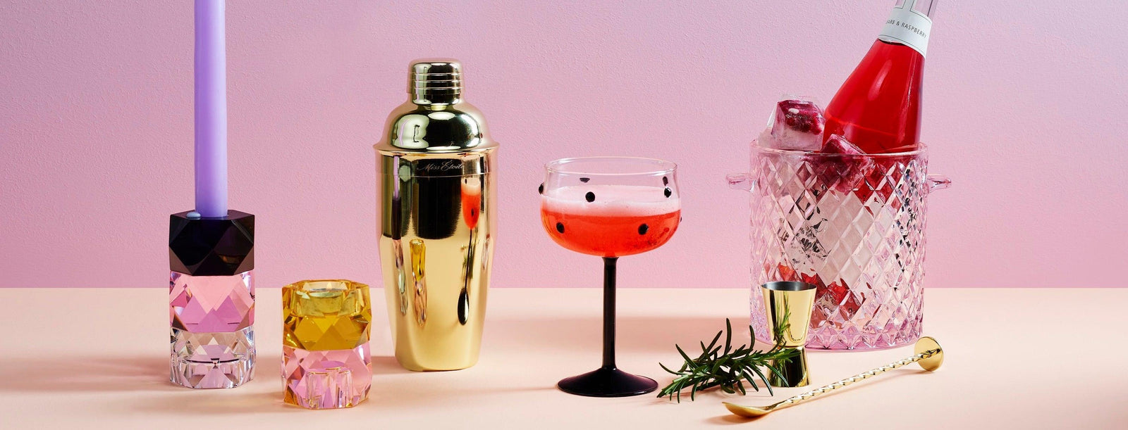 Bunter Tisch mit goldfarbenem Cocktailshaker, Kristallglas, Kerzenhalter und Sektkühler, Glamour Deko von Codeso Living.