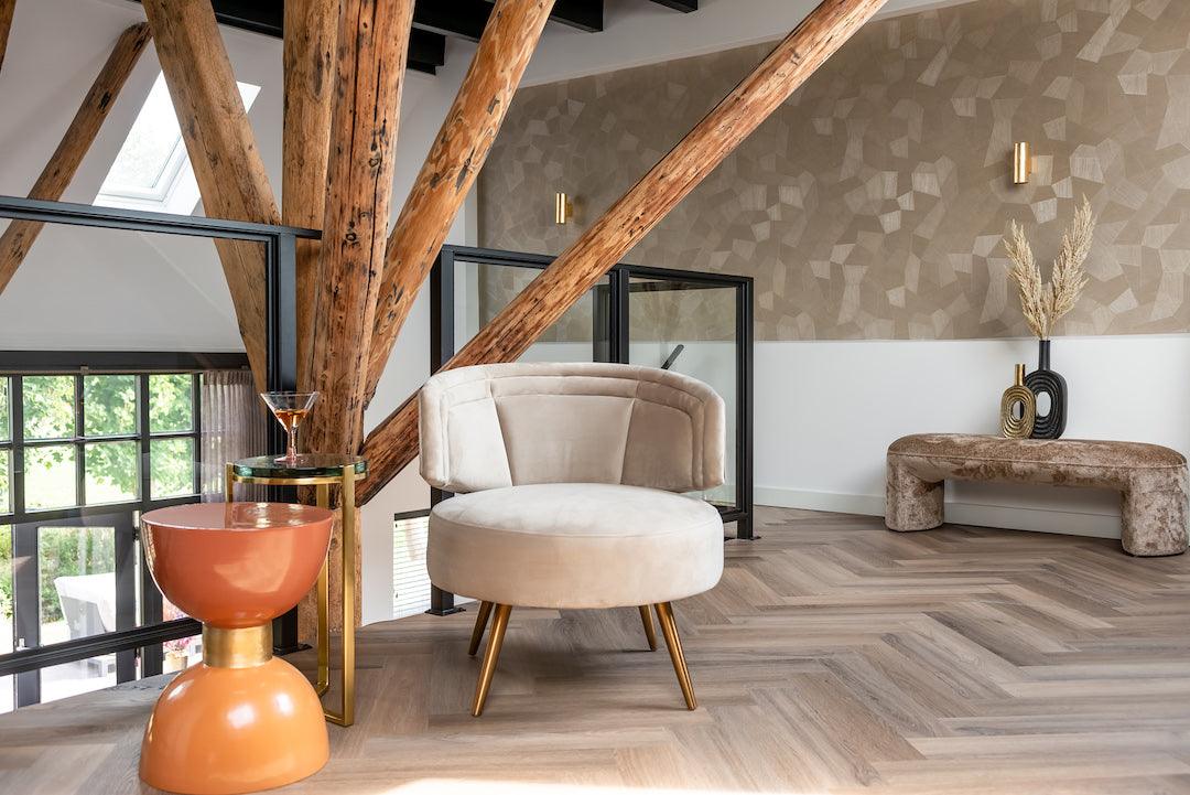 Wohnzimmer mit Designer-Sessel, modernem Beistelltisch und luxuriös dekorierter Bank bei Codeso Living