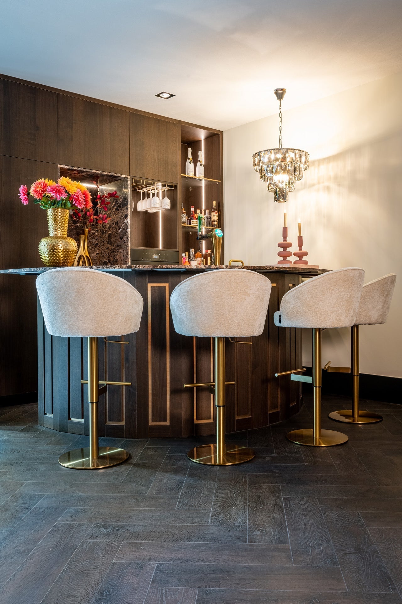 Luxuriöse Bar mit eleganten Barhockern, goldenem Dekor und Kronleuchter in Glamour-Interior-Design
