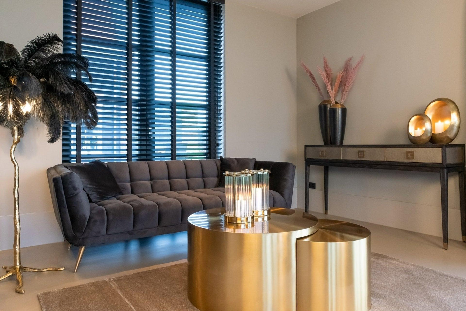 Modernes Wohnzimmer mit grauem Samtsofa, goldenen Tischen und Glamour-Deko von Codeso Living
