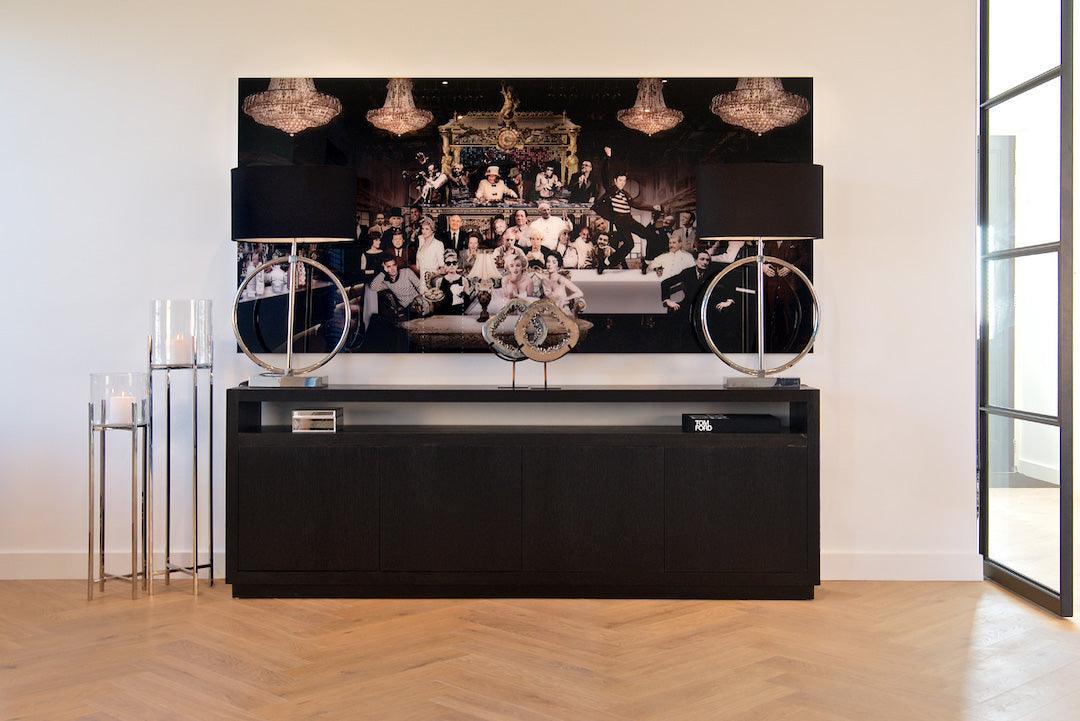 Modernes Wohnzimmer mit Richmond Interiors Oakura Sideboard, schwarzem Deko-Lampenpaar, Kunstbild mit Glamour-Motiv und stilvollen Kerzenhaltern auf hellem Holzfußboden.