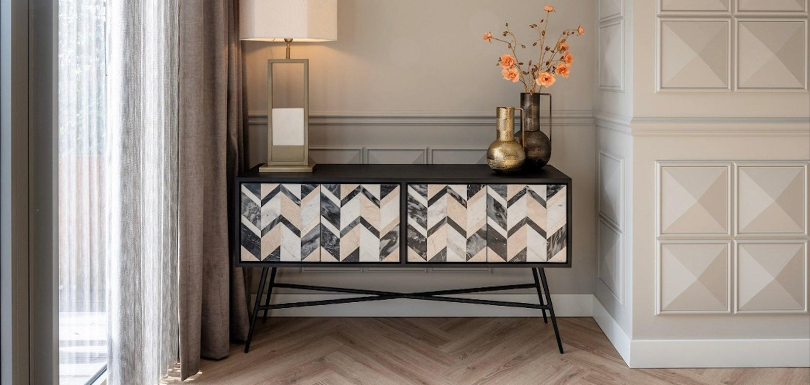 Modernes Sideboard im Art-Déco-Stil mit Chevron-Muster, goldene Vasen und Tischlampe, Glam Interior
