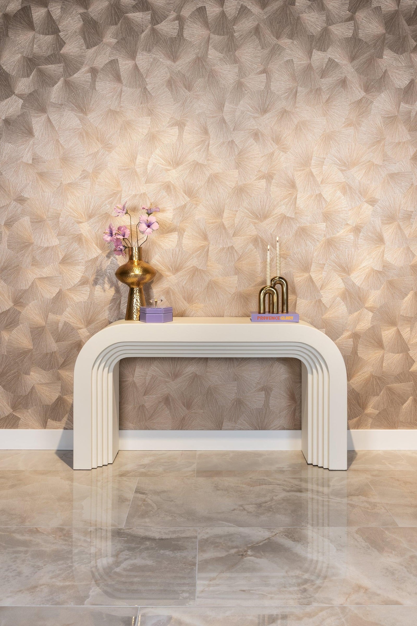 Modernes Richmond Interiors Konsolentisch in Creme vor gemusterter Tapete, dekoriert mit goldener Vase, lila Blumen und Kerzen, luxuriöses Maximalismus-Interior von Codeso Living.