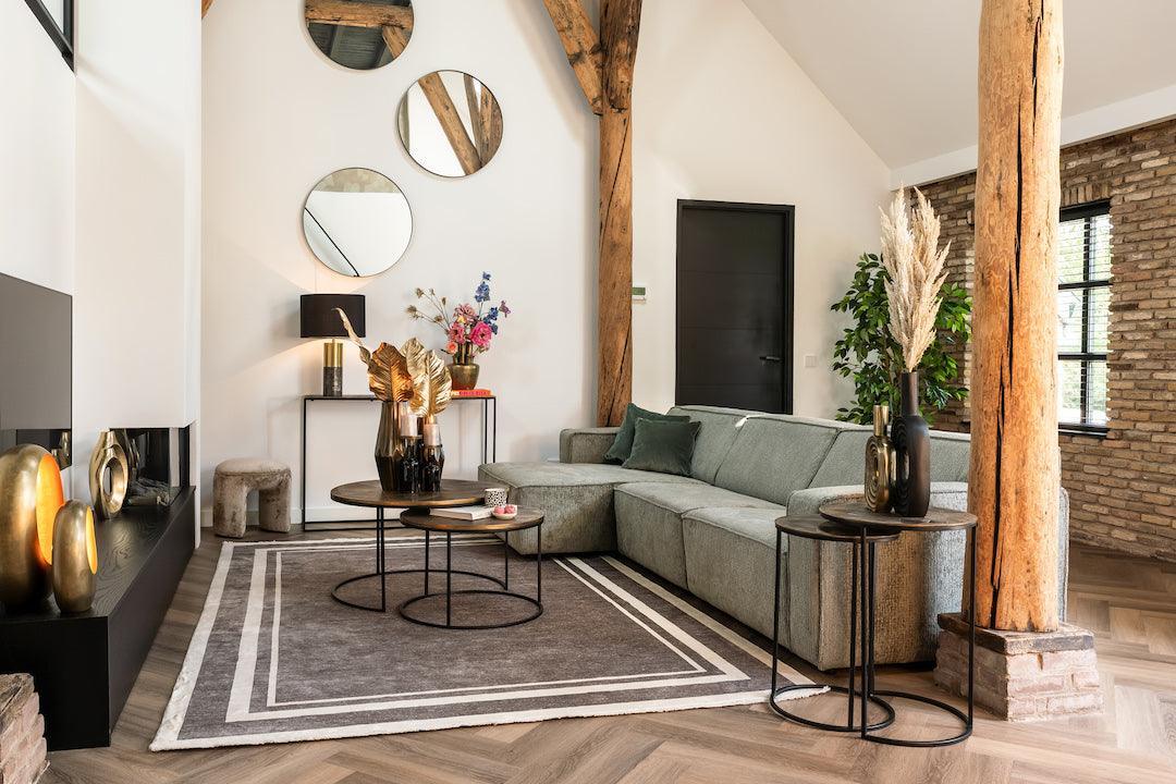Modernes Wohnzimmer mit luxuriösem grauen Ecksofa, goldenen Deko-Accessoires, Design-Couchtischen und glamourösem Interior im Maximalismus-Stil.
