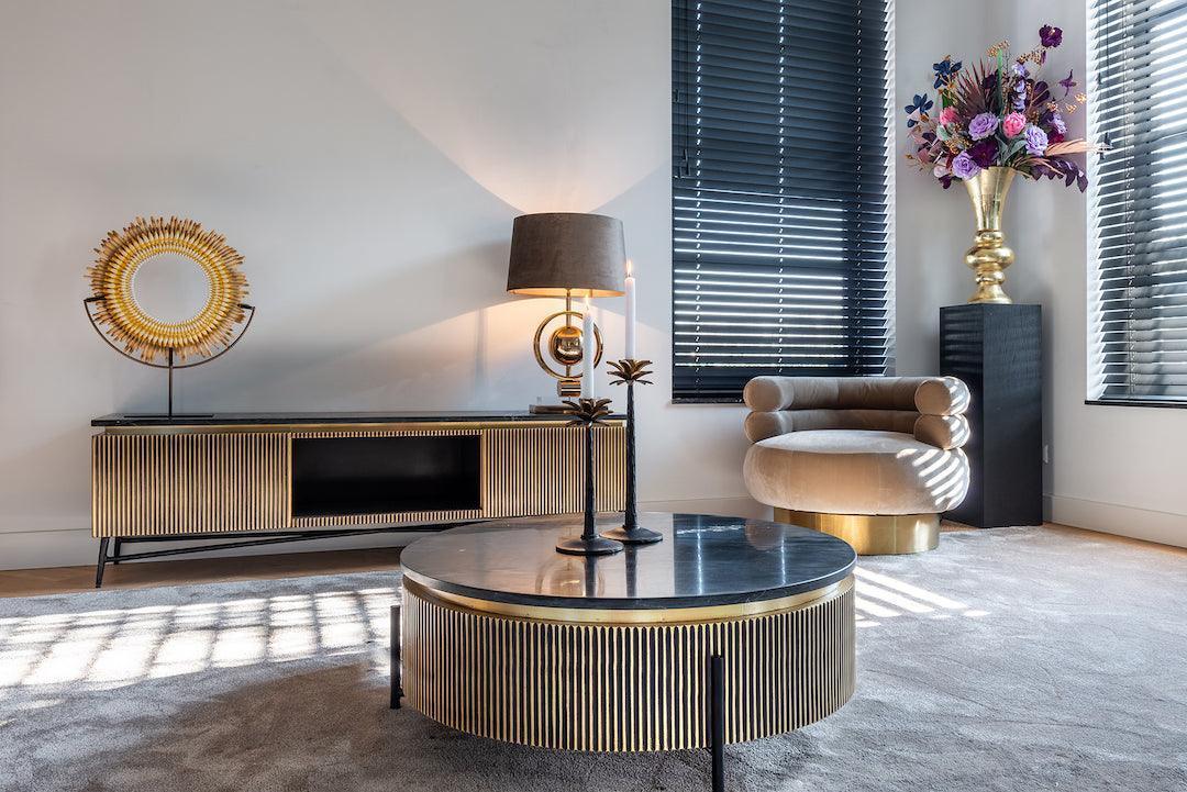 Modernes Wohnzimmer mit glamourösem TV-Lowboard, Rundtisch, Design-Sessel und Deko von Codeso Living.