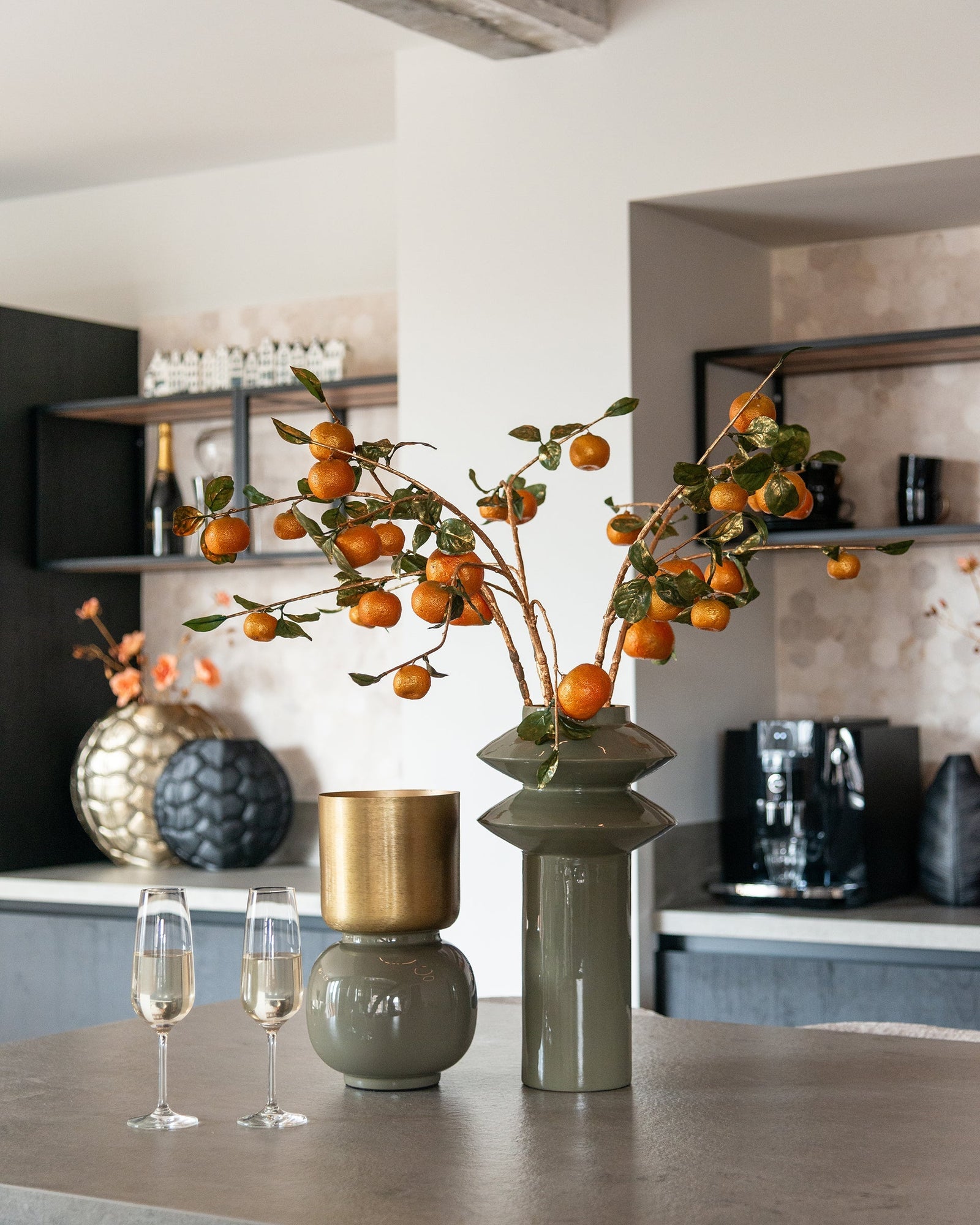 Moderne Richmond Interiors Vasen mit Deko-Zweigen und Champagner auf eleganter Kücheninsel