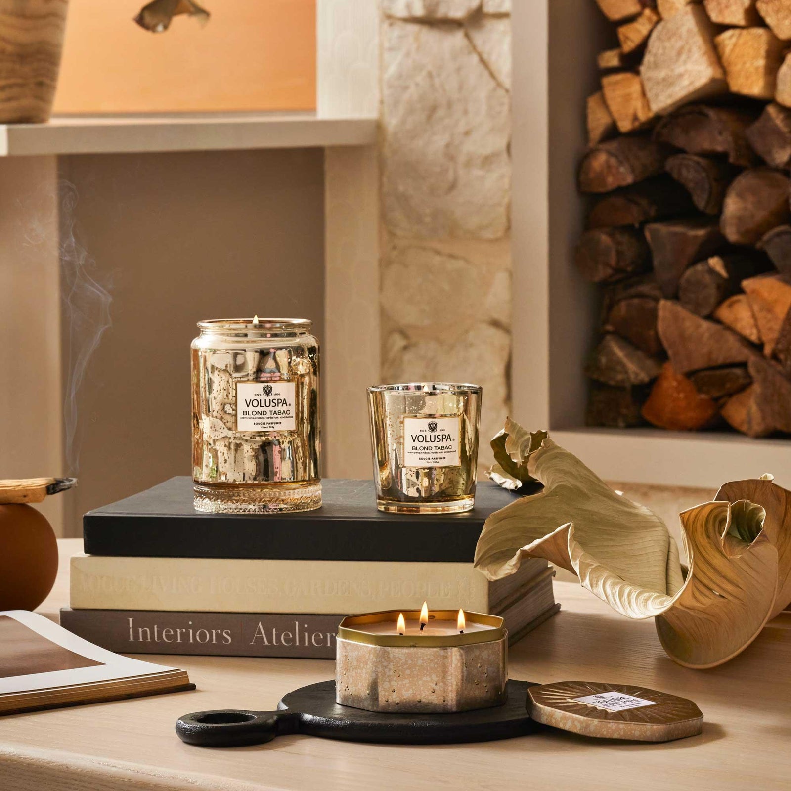 Voluspa Blond Tabac Duftkerzen im eleganten Glas, dekorativ arrangiert auf Wohnzimmertisch vor Kamin