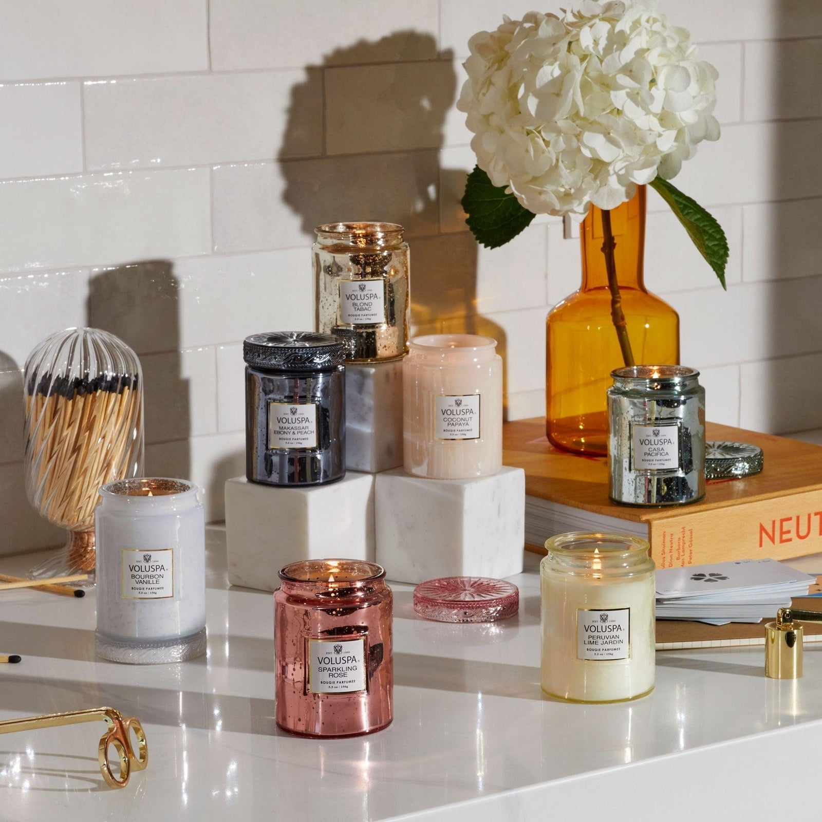 Voluspa Duftkerzen Sparkling Rose und andere Duftrichtungen im eleganten Glas auf stilvoller Kommode mit goldener Schere und weißer Blume, Glam Interior Deko von Codeso Living
